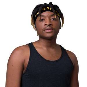Unity is Strength Headband in black with yellow text male front view. Stretchy and comfortable. Make a statement, available at Rastaseed clothing and accessories.