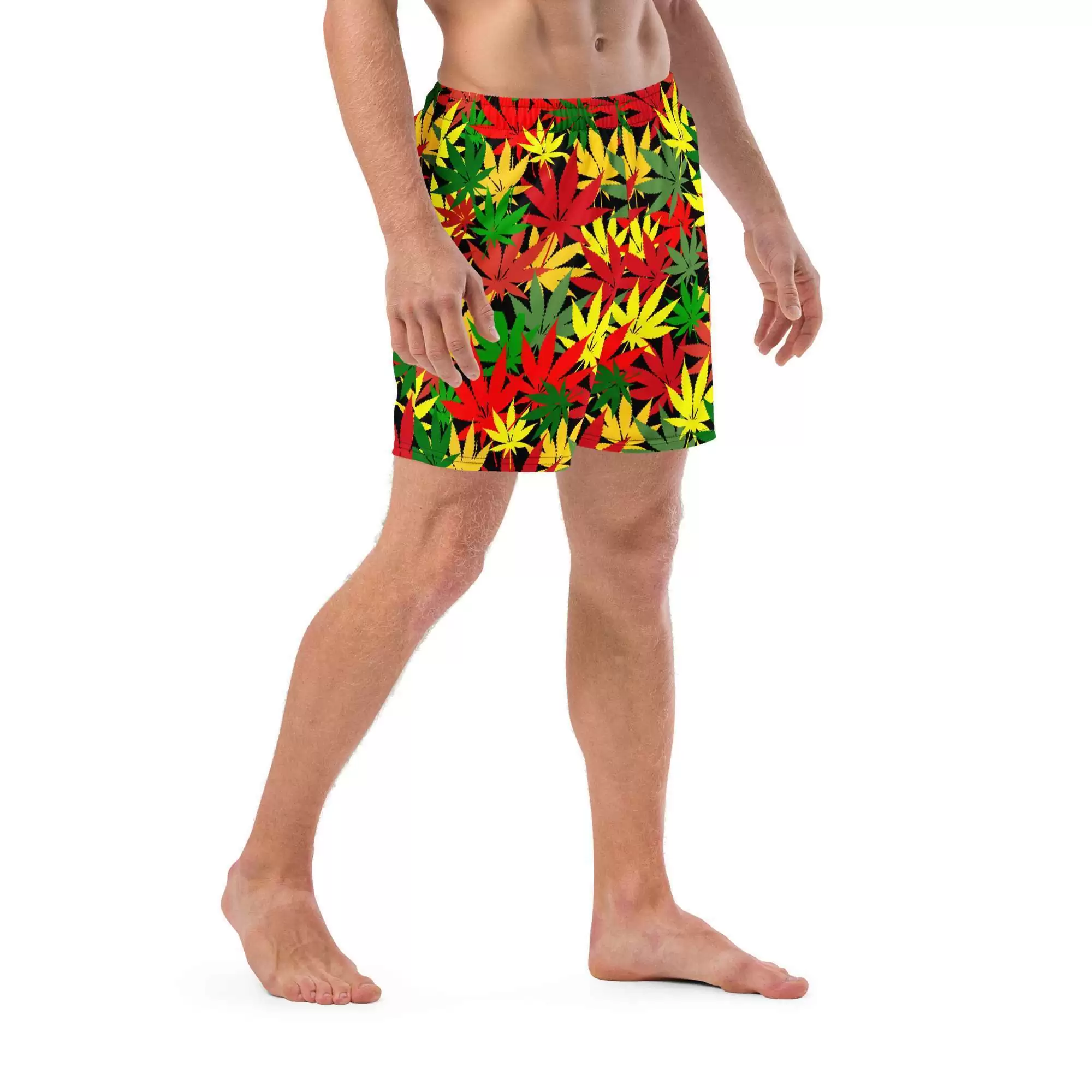 Hemp Leaf Boardshorts in Rasta colors of red gold and green with black background and stitching side front model view. Rastafarian shop for clothing and accessories.