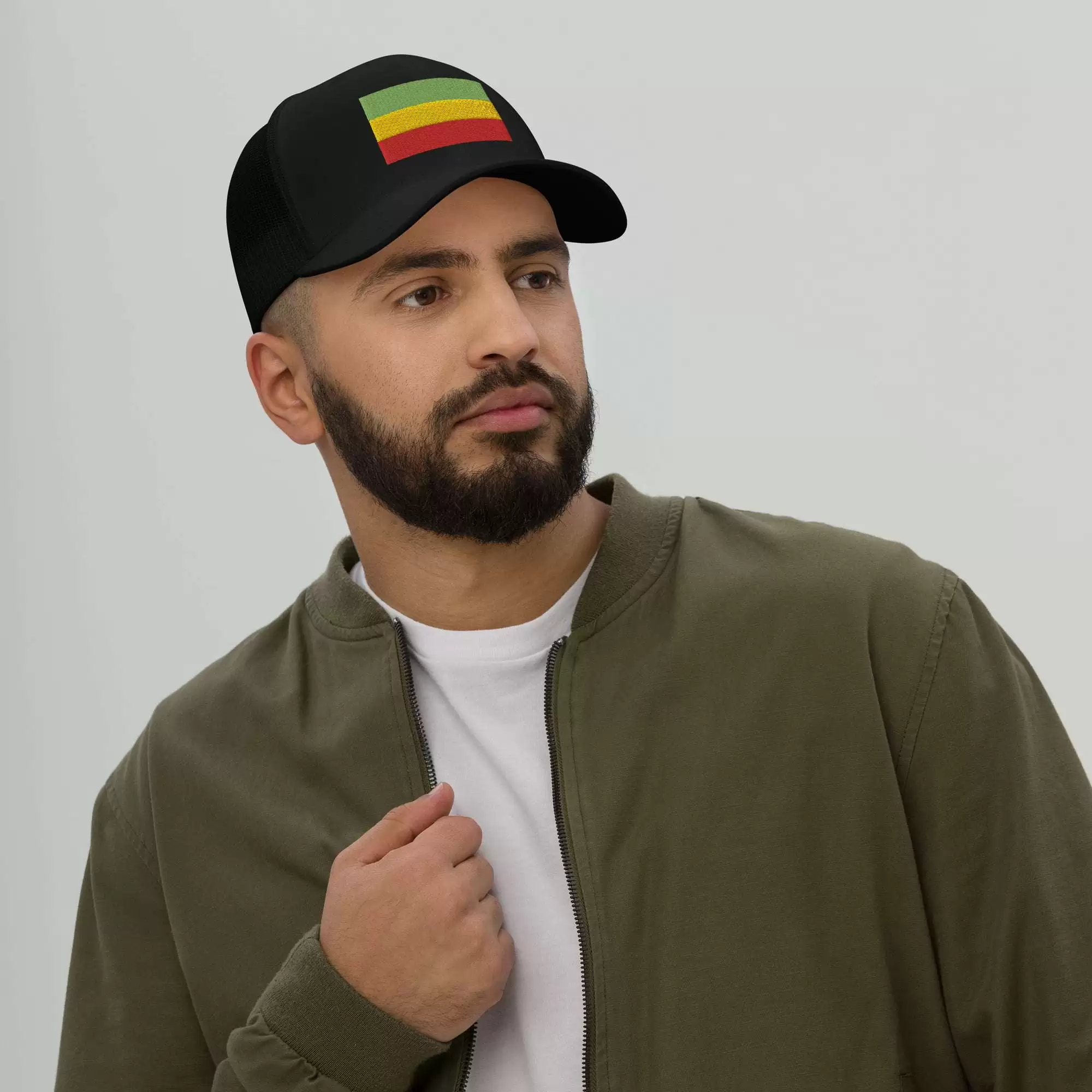 Rastafari cap front male model view with embroidered Rasta flag across the front. Red gold and green. Black cap great for island vacation or Reggae Festival.