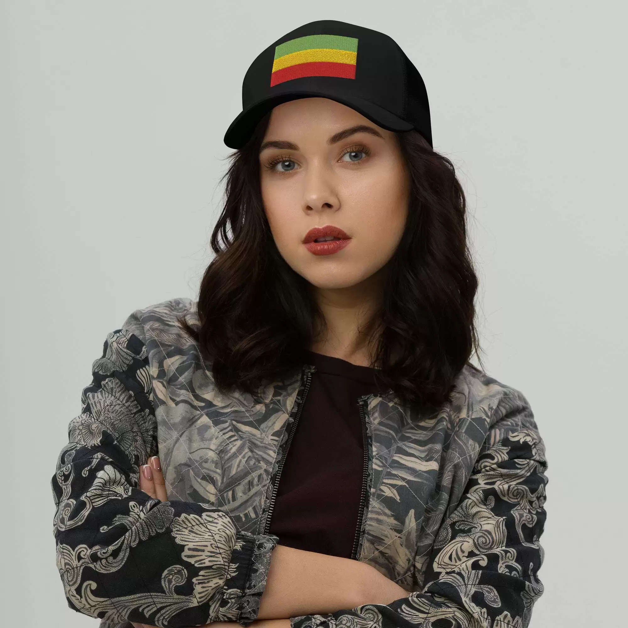 Rastafari cap front female model view with embroidered Rasta flag across the front. Red gold and green. Black cap great for island vacation or Reggae Festival.