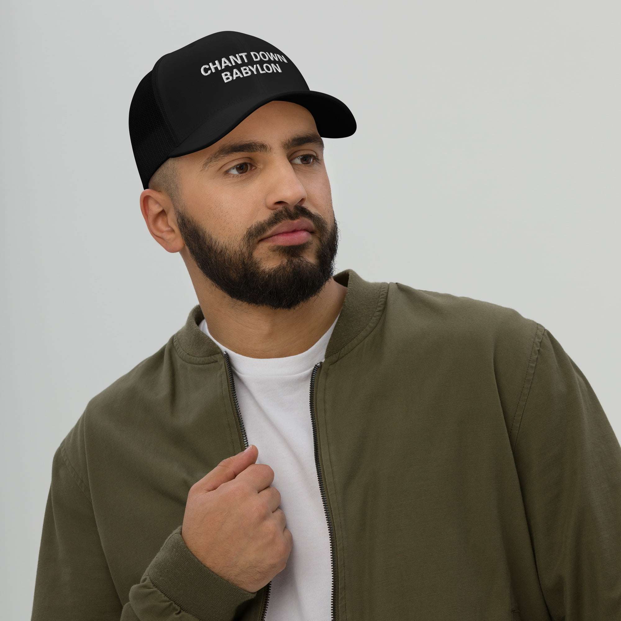 Rastafari hat front male modelf view with Chant Down Babylon embroidered across the front. Trucker style hat in black, great for vacation or Reggae Festival.