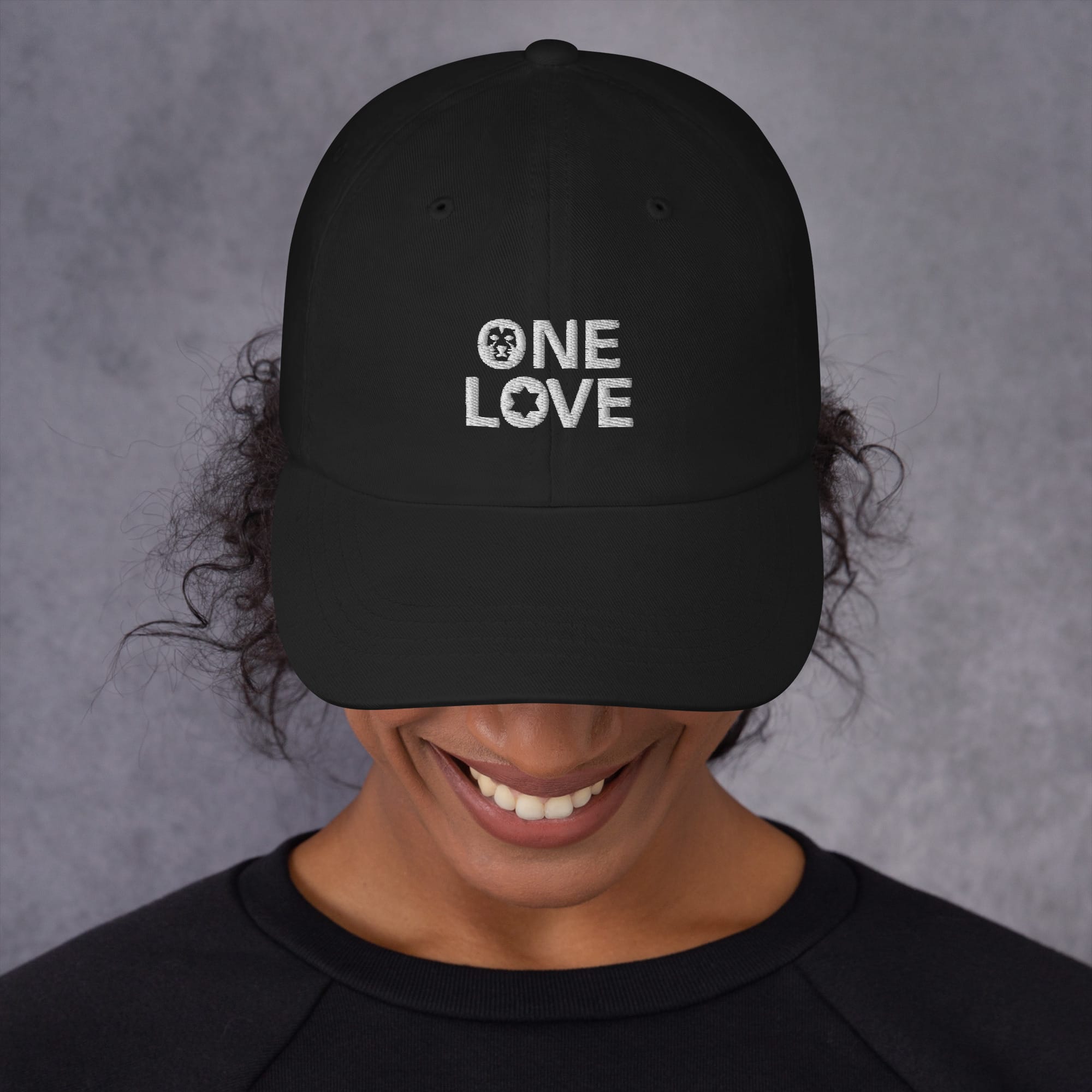 One Love Cap available in two colors, khaki camo or black. White embroidered lettering on dad hat style cap. Rastaseed original designs. Front black model view.