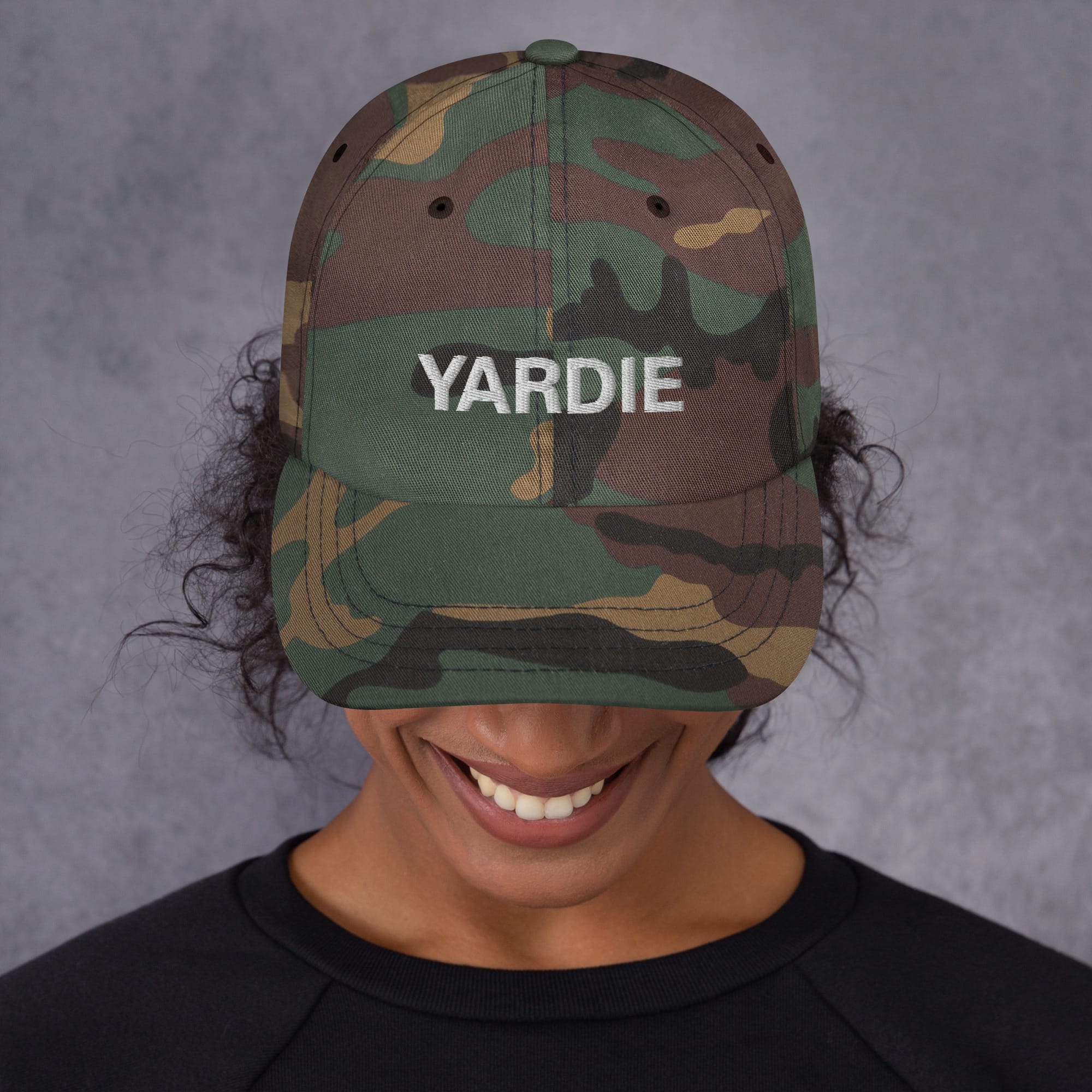 Yardie Jamaican Patois Cap front view in dad hat style. Available in Khaki camouflage and black. Rastaseed original Rastafarian merchandise and clothing shop. Front camo model view.