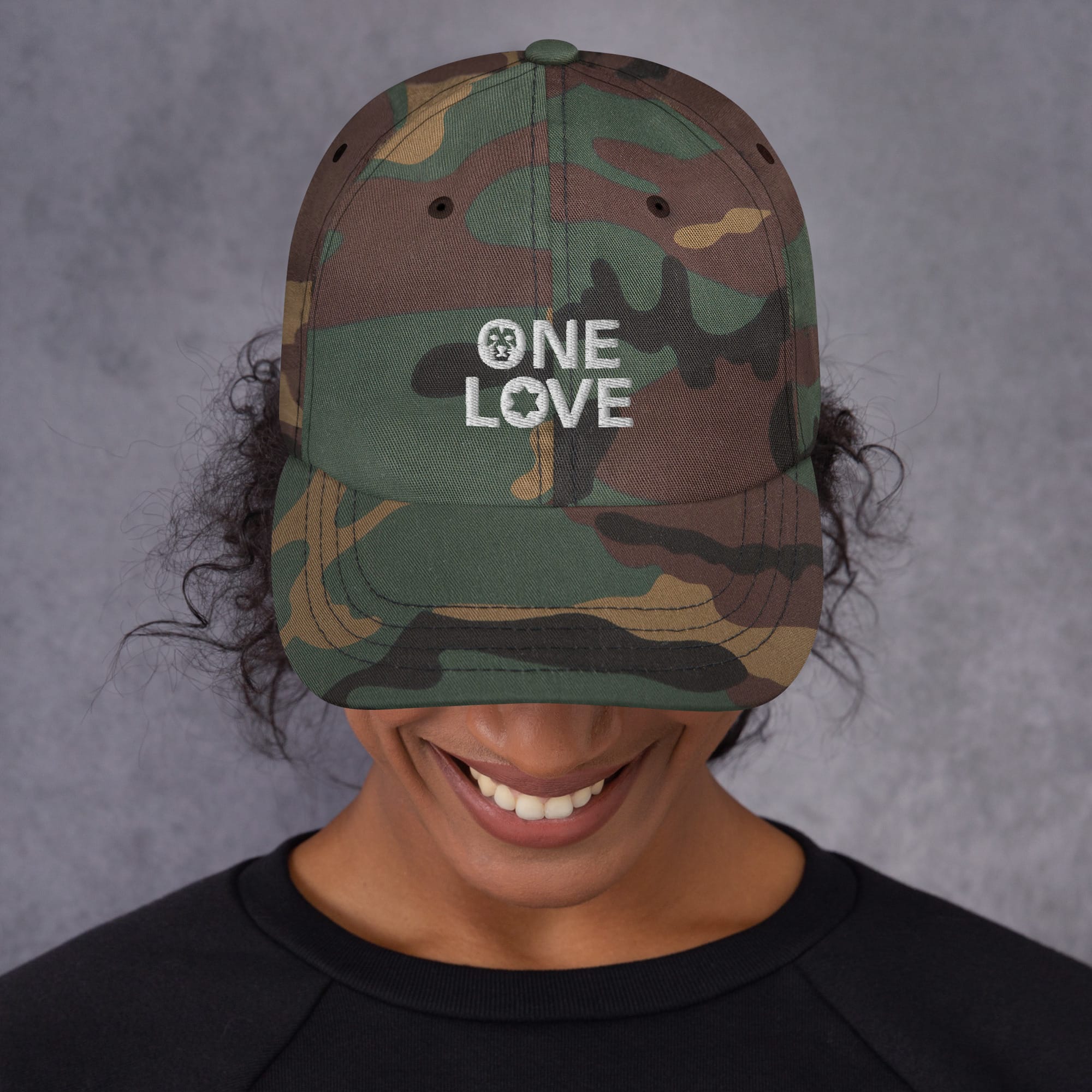 One Love Cap available in two colors, khaki camo or black. White embroidered lettering on dad hat style cap. Rastaseed original designs. Front camo model view